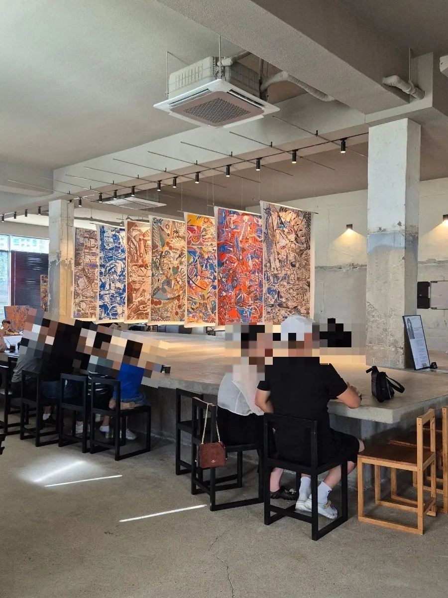 Café interior with green scenery visible through floor-to-ceiling windows