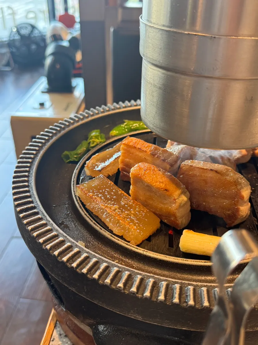Staff member grilling the meat on the plate
