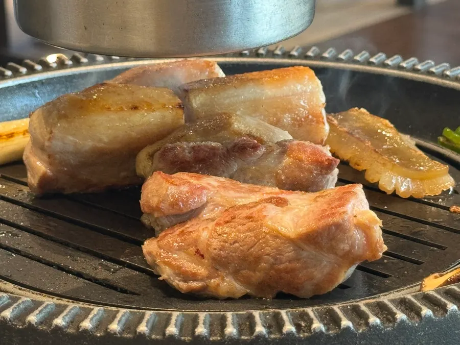 Whole pig and vegetables cooking on the grill