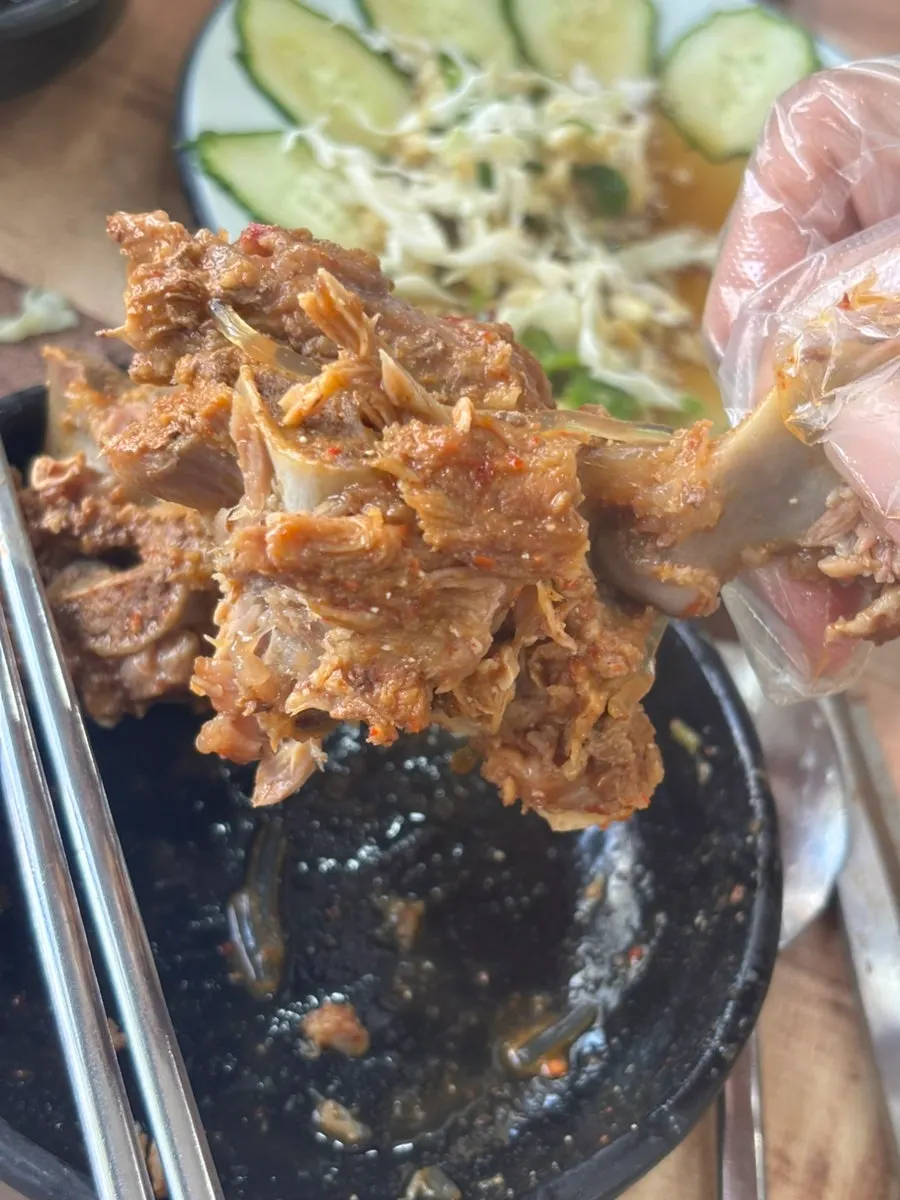 A piece of gamjatang meat dipped in broth