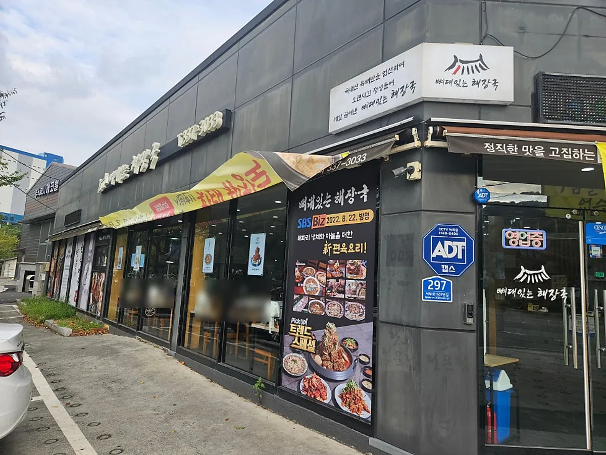 Exterior and parking area of Ppyeodae Itneun Haejangguk Juchon Branch in Gimhae
