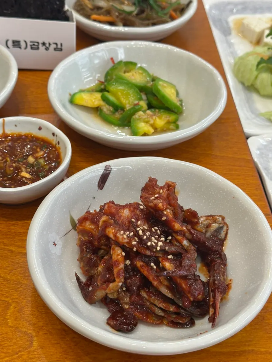 Banchan being laid out for the ray stew set at Gaya Kkeutjip