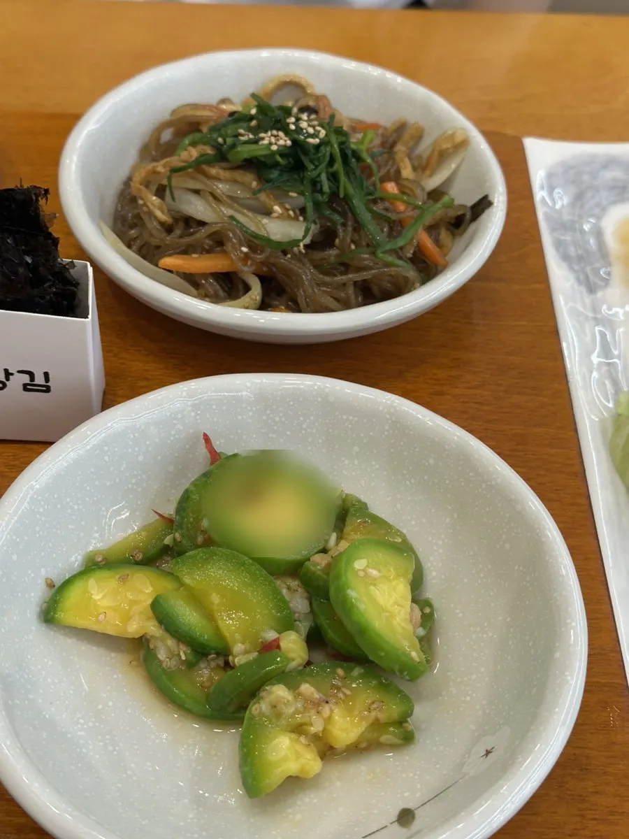 Plate of japchae and greens among Gaya Kkeutjip's banchan