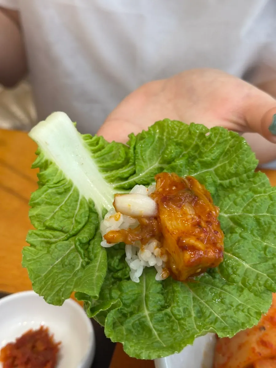 A bite of ray meat wrapped in lettuce