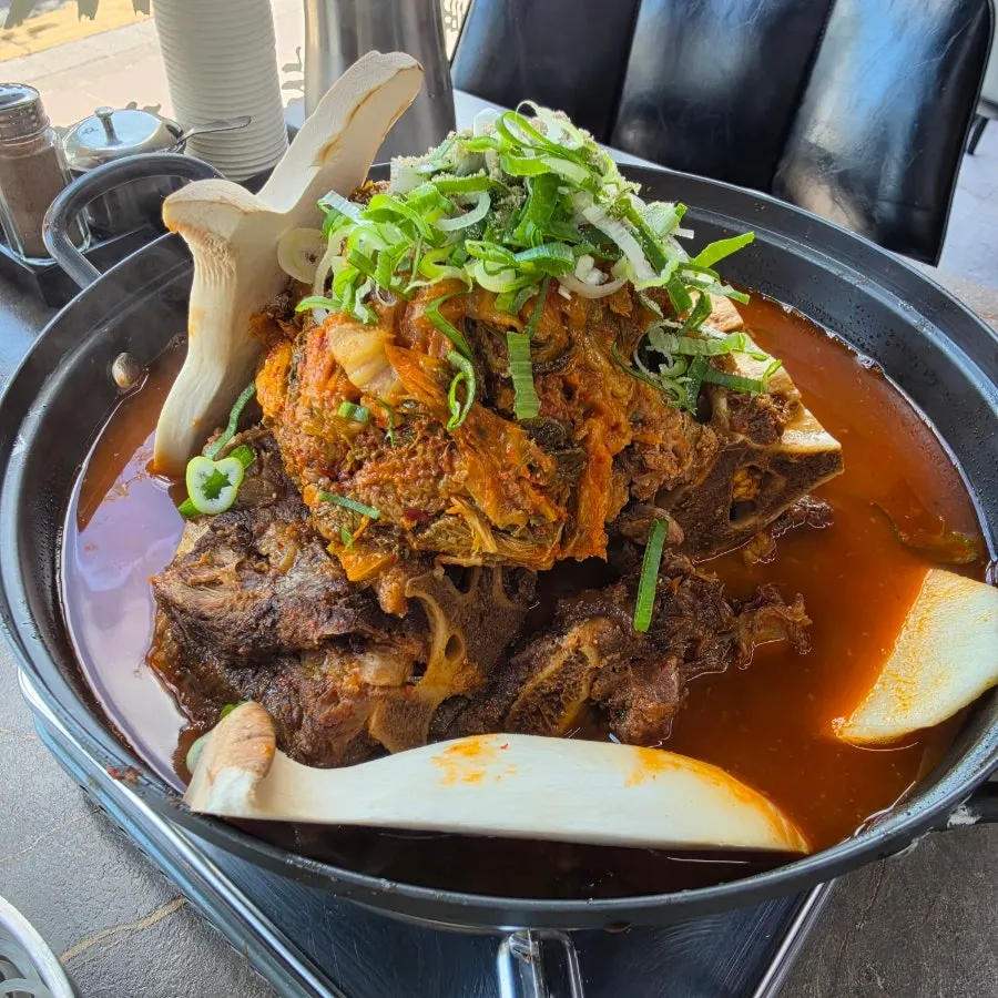 Plate of add-ins next to the simmering gamjatang pot