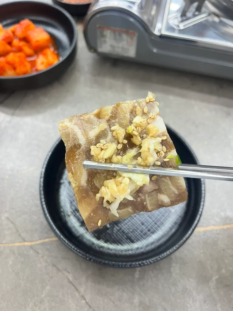 Plate of boiled pork slices topped with garlic and chili seasoning