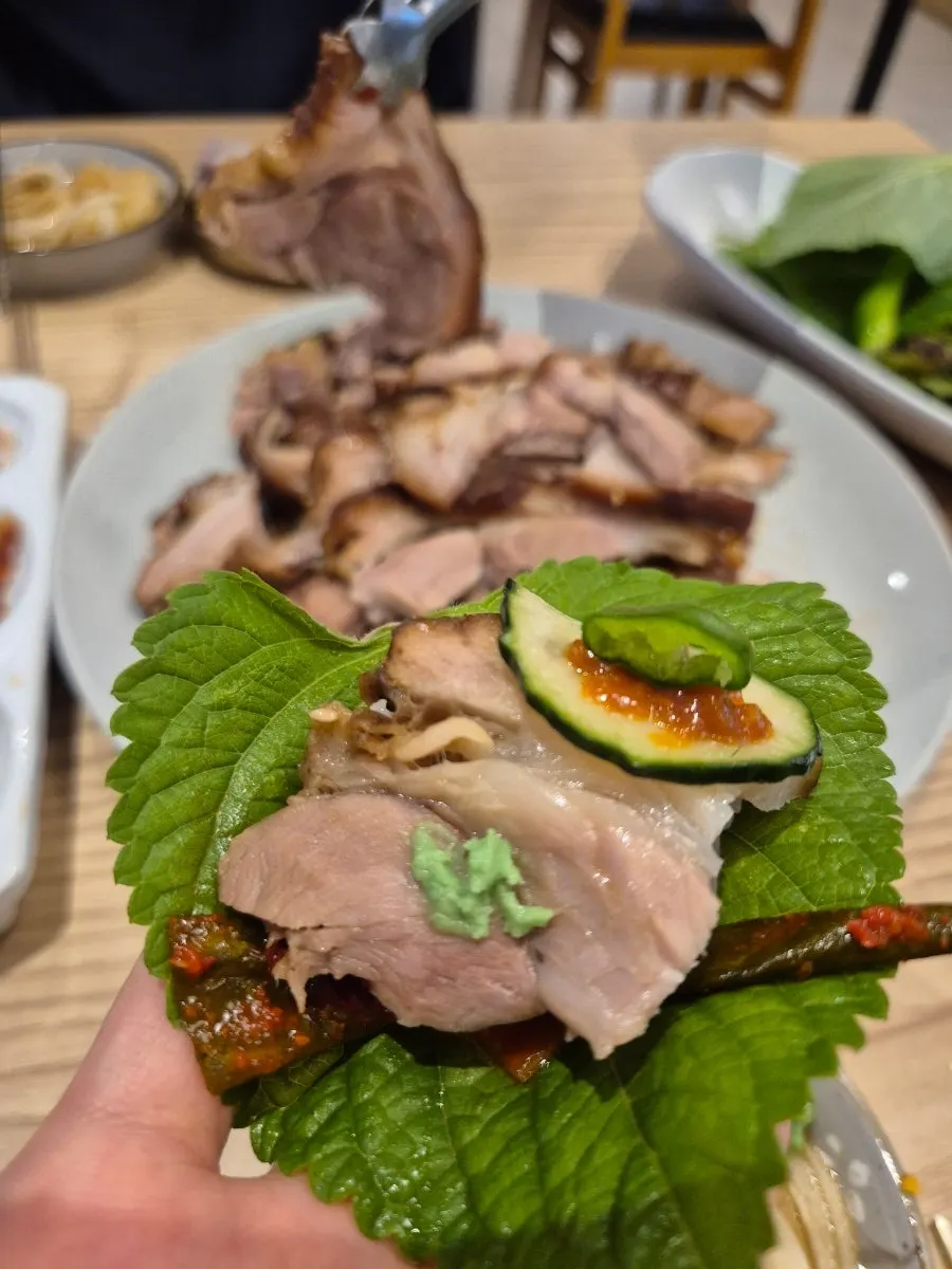 A piece of jokbal meat picked up with chopsticks