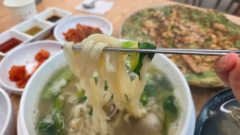 Kalguksu noodles topped with clams