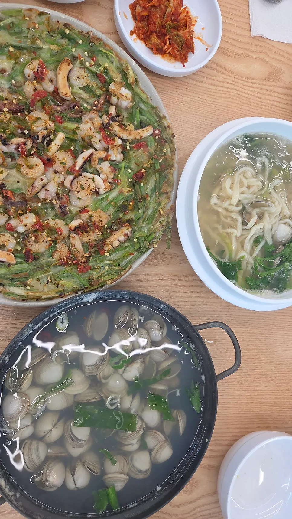 Full table spread of kalguksu, pancake, and clam soup