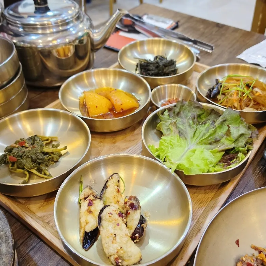 나물과 짭조름한 반찬이 담긴 접시