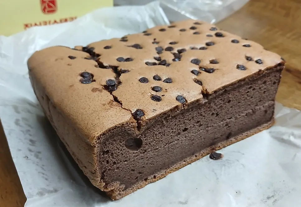 A piece of Chocolate Castella showing the chocolate chip topping