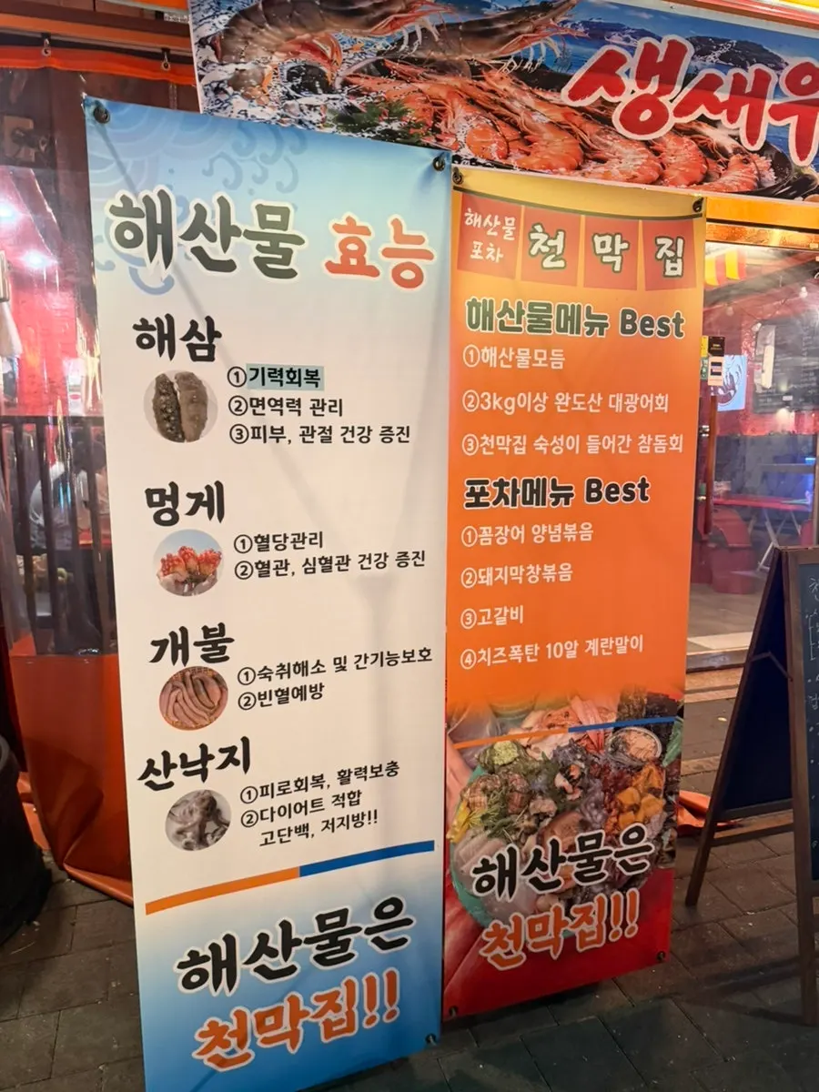 Outdoor sign listing seasonal seafood at Cheonmakjip