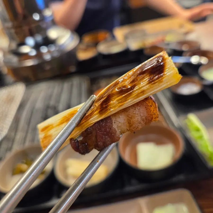 파채와 김치를 얹은 고기 한 점