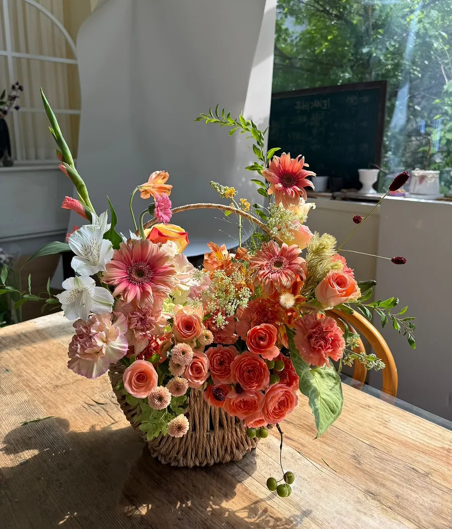 Flower shop space with large windows, plants, and fresh flowers