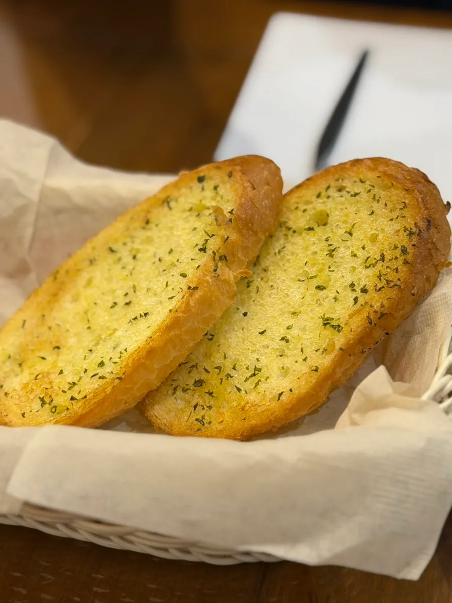 Soup topped with bread pieces and herb powder