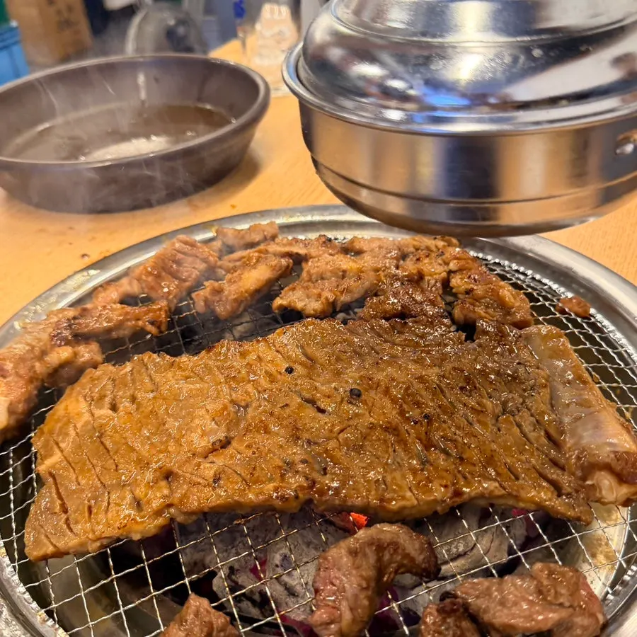 Large king pork ribs placed on the charcoal grill