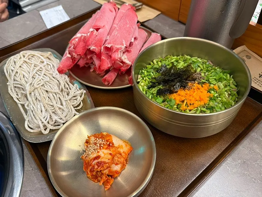 A plate of shabu vegetables and shabu meat