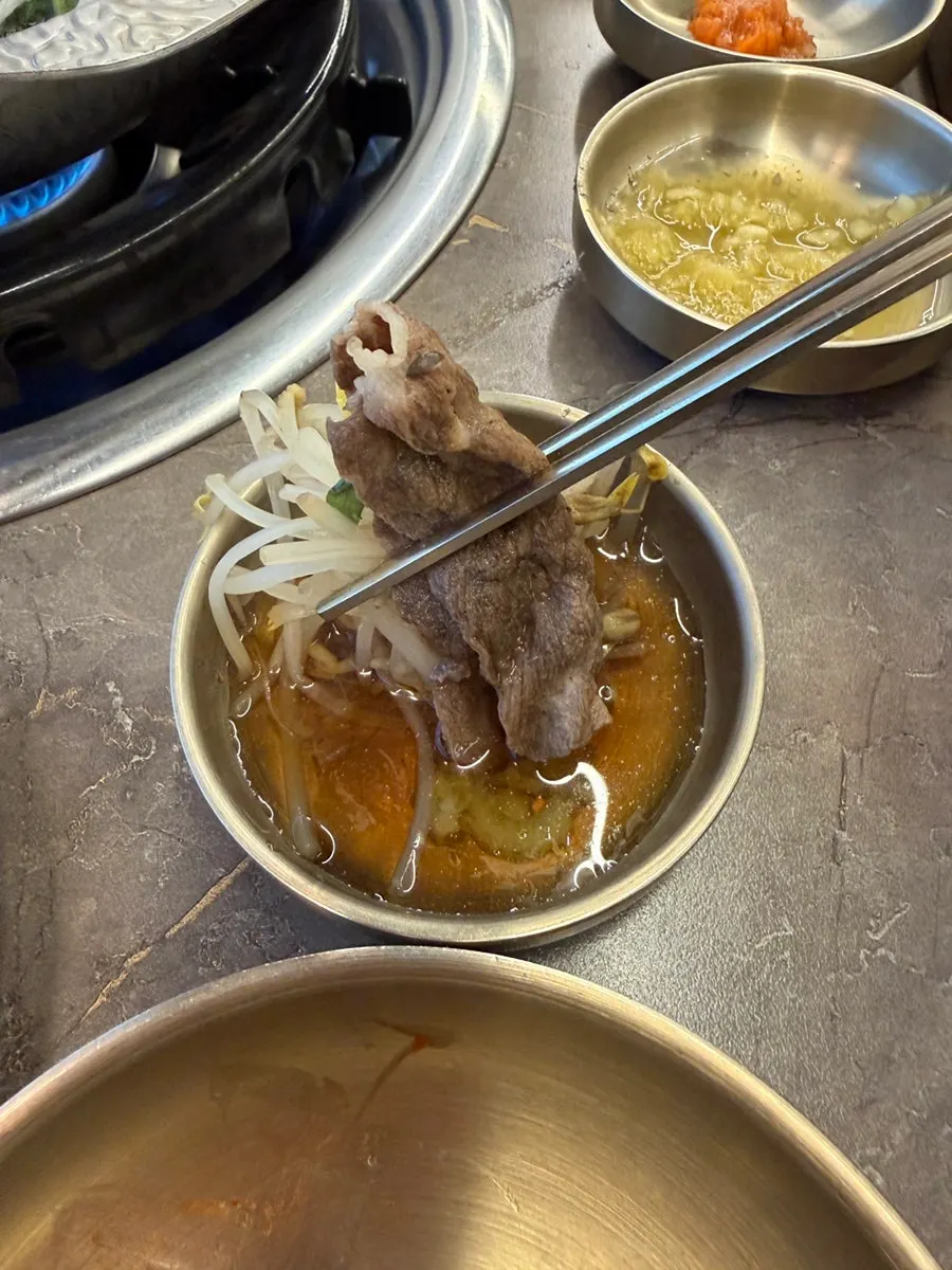 Pot filled with cooked shabu meat and vegetables