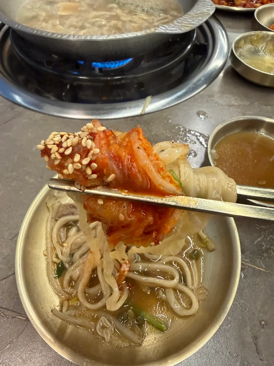 Rye kalguksu noodles simmering in the broth