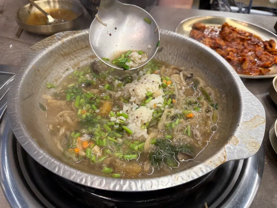 A bowl of rye kalguksu eaten together with kimchi