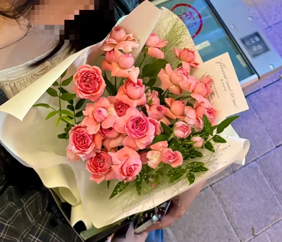 Cheerleader rose bouquet held at a bus stop