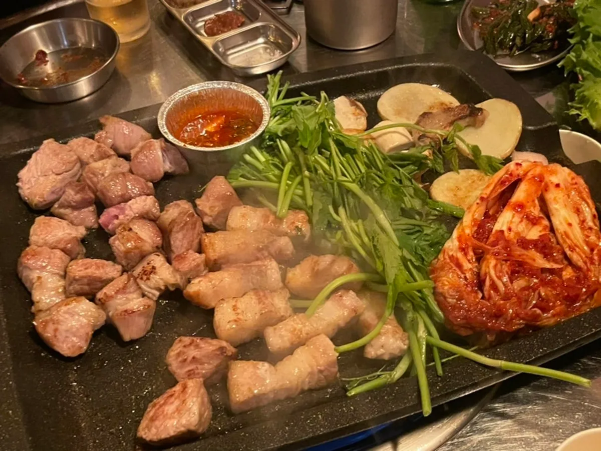 구워진 고기 옆에 올린 미나리와 김치
