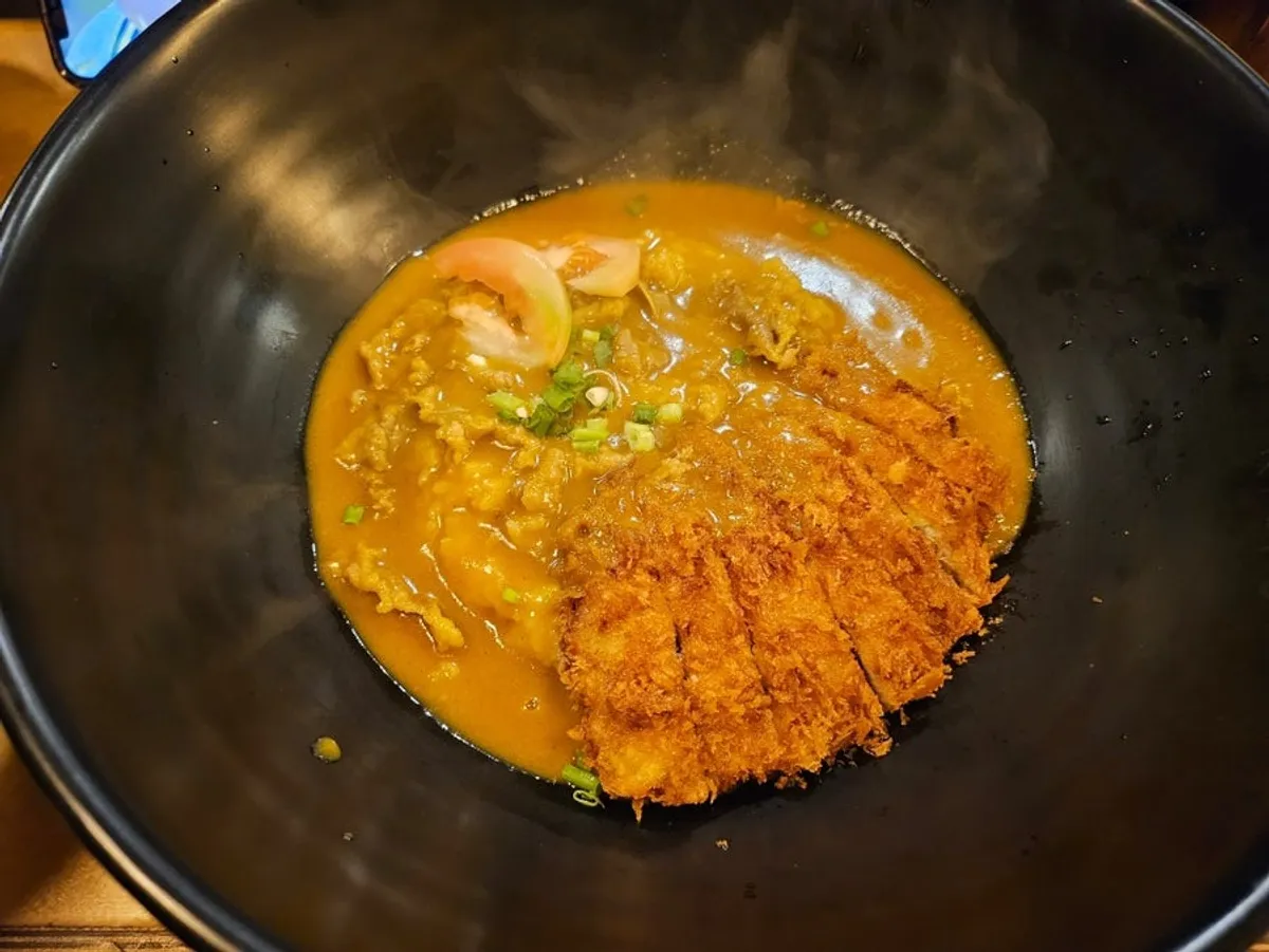 검은 그릇에 담긴 카레소고기돈까스