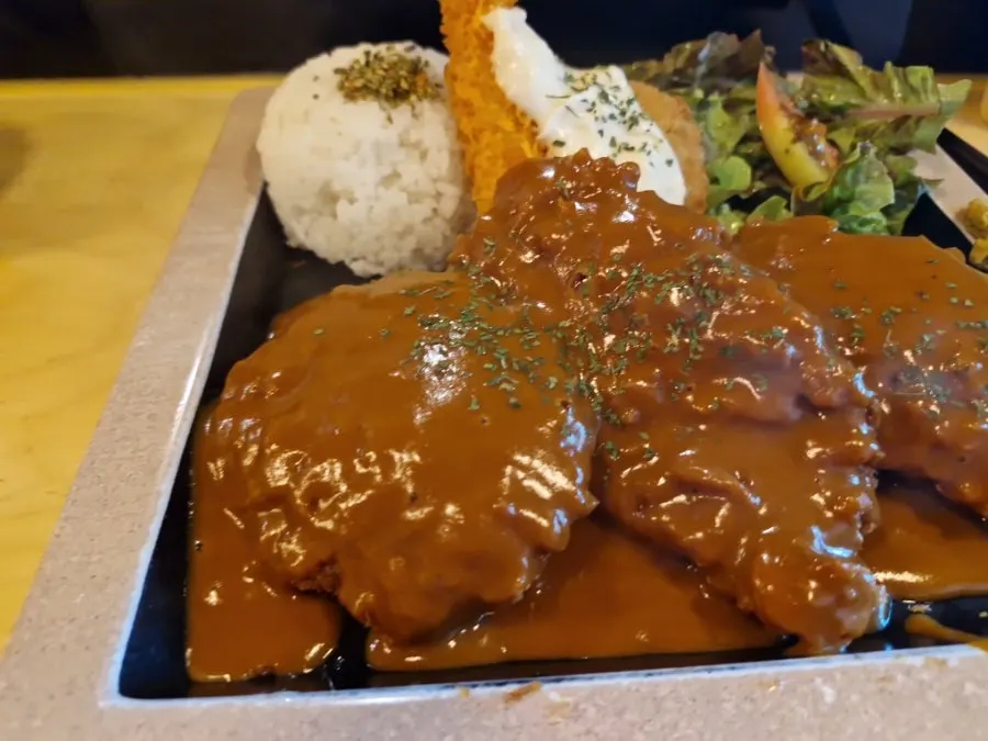 Pork cutlet generously covered in demiglace sauce