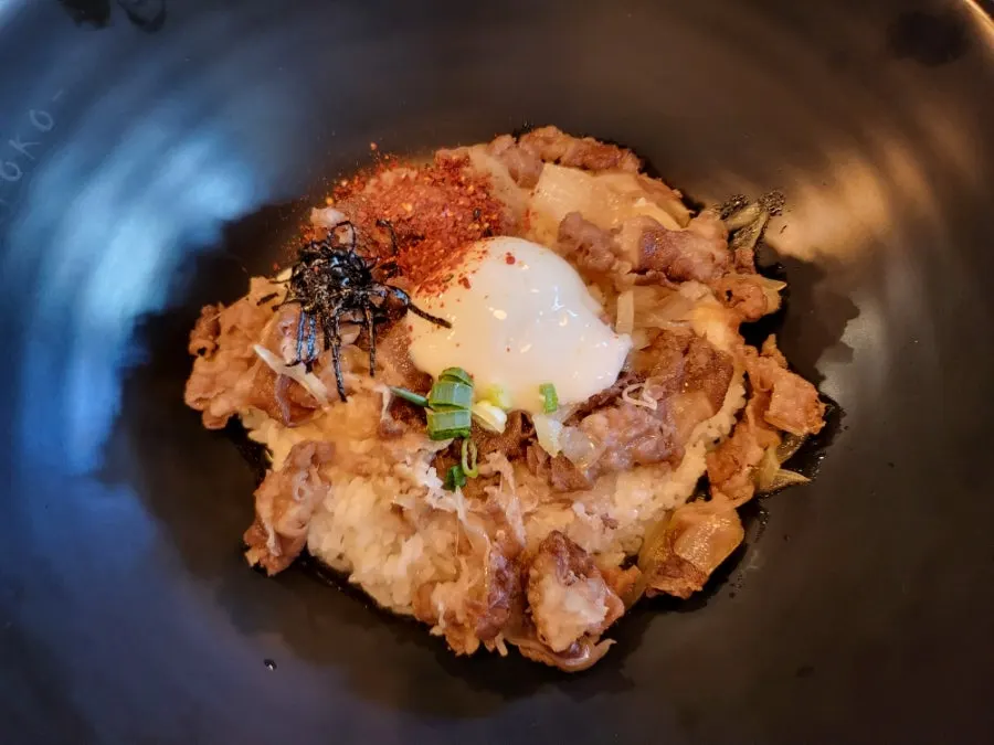 Rice topped with a poached egg served alongside the jumbo pork cutlet