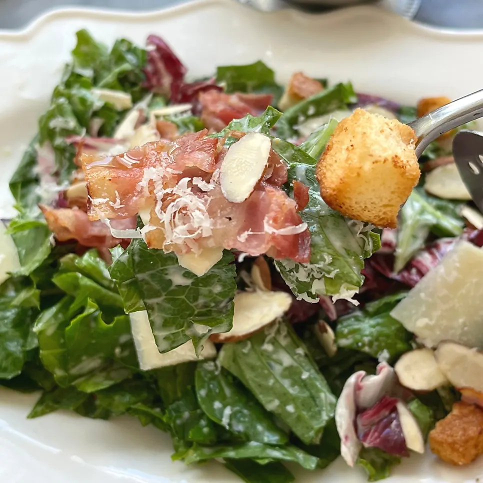 A plate of Caesar salad finished with almonds