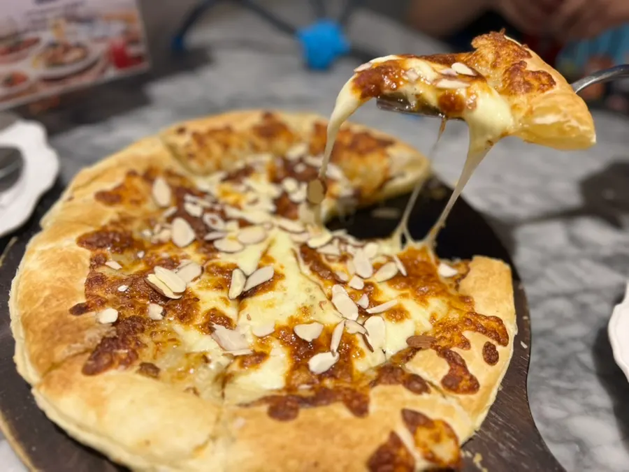 A slice of gorgonzola pizza dipped in honey