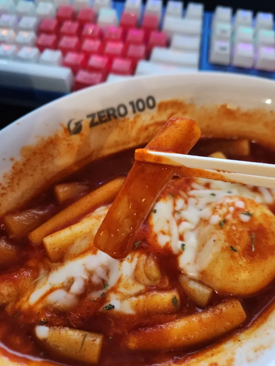 Close-up bite of cheese-topped tteokbokki