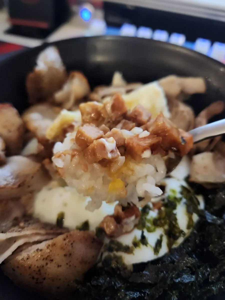 Spam mayo rice bowl topped with egg and seaweed flakes