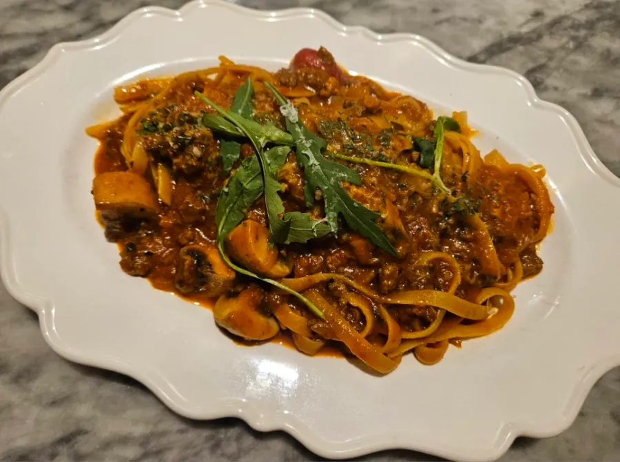 A plate of pasta piled with ragu sauce