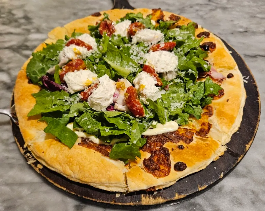 Pizza topped with ricotta cheese and roasted tomatoes