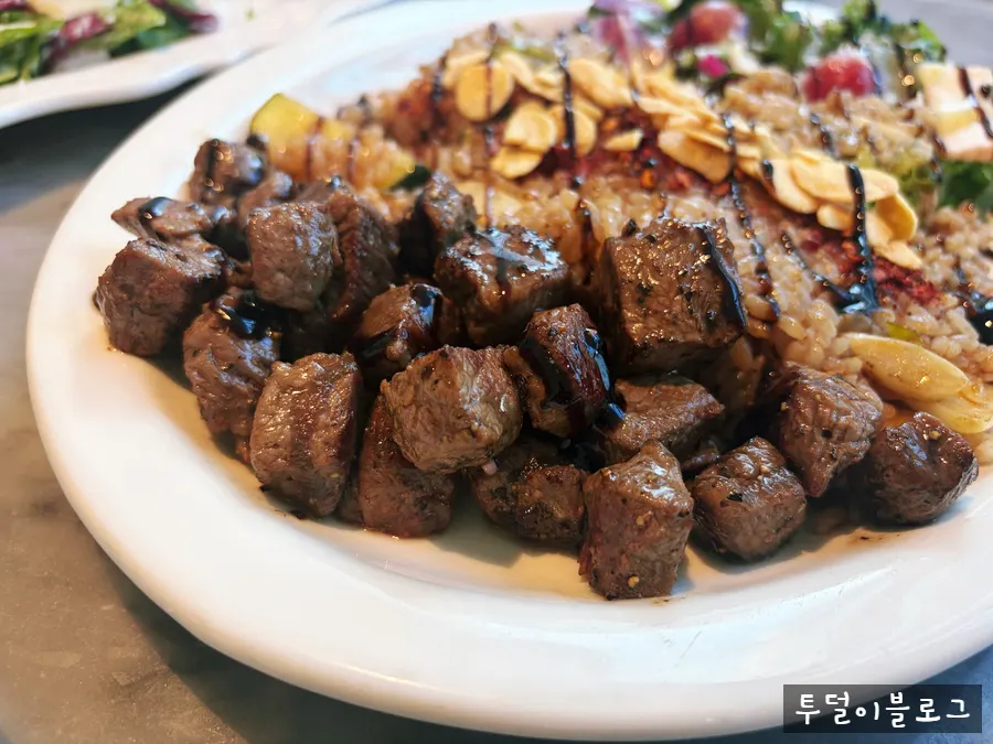 A piece of cube steak placed on top of the pilaf