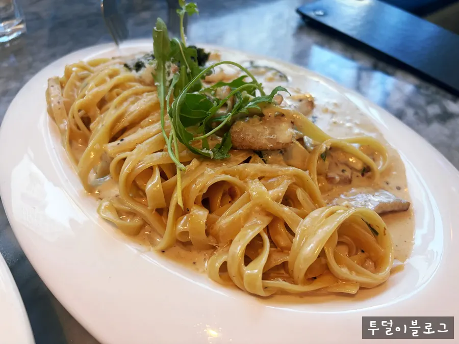 Close-up of green onion and cream sauce blended in the pasta