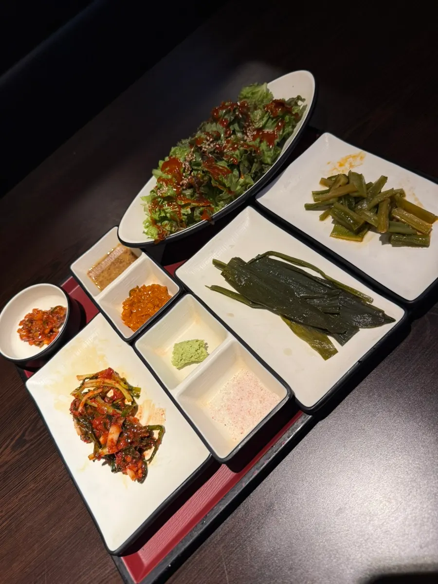 Giun's side dish spread including wild garlic leaves, scallion kimchi, and marinated gungchae
