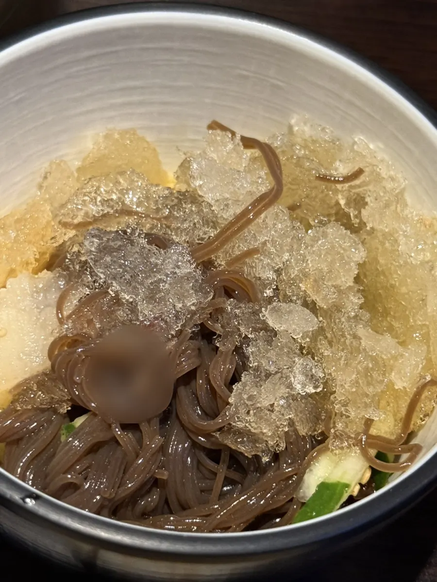 A bowl of cold naengmyeon loaded with shaved ice to finish the meal