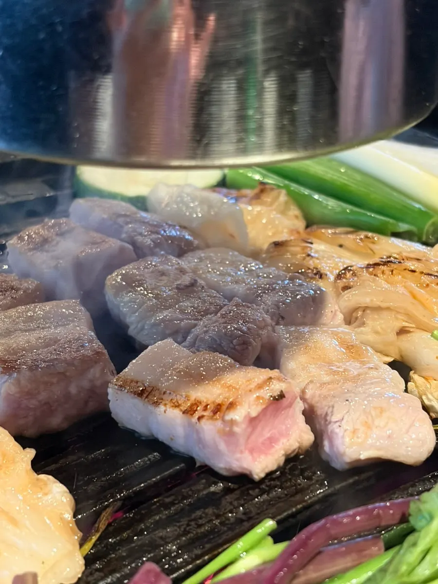 Thick galbi-samgyeop grilling alongside vegetables