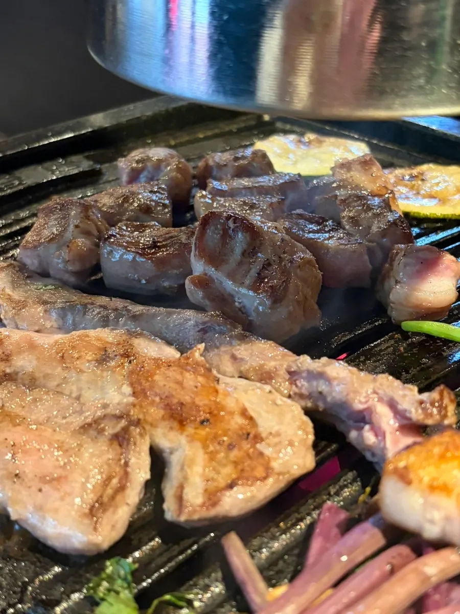 Thick pork neck cooking on the grill