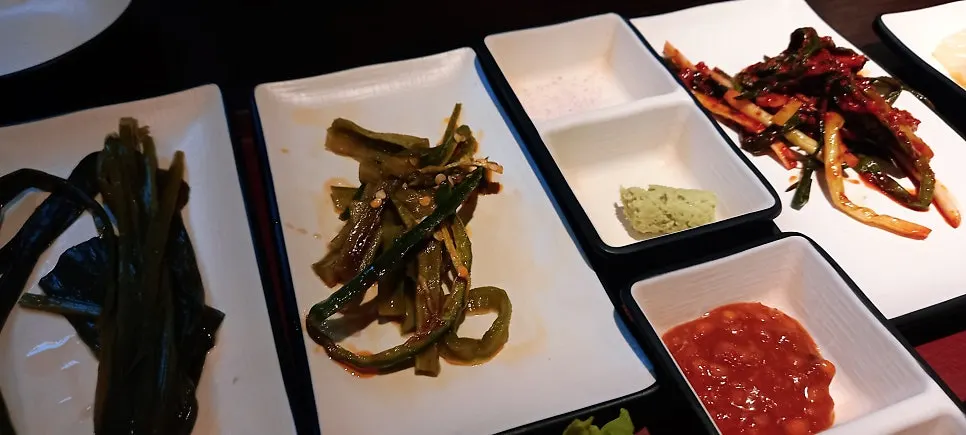 Susunan lauk myeongi-namul, salad selada, dan baek-kimchi