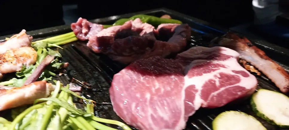 Samgyeopsal yang sudah masak bersama lauk pelengkap