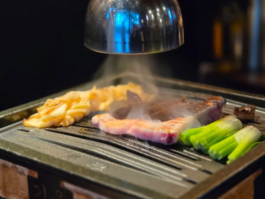The owner grilling galbi samgyeopsal at the table