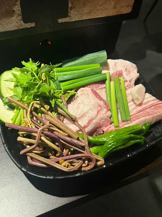 Meat and white kimchi grilling on the tabletop grill