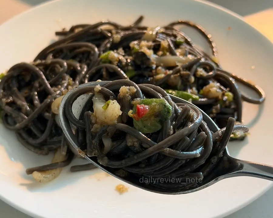 Close-up of pasta noodles with cuttlefish tucked between them