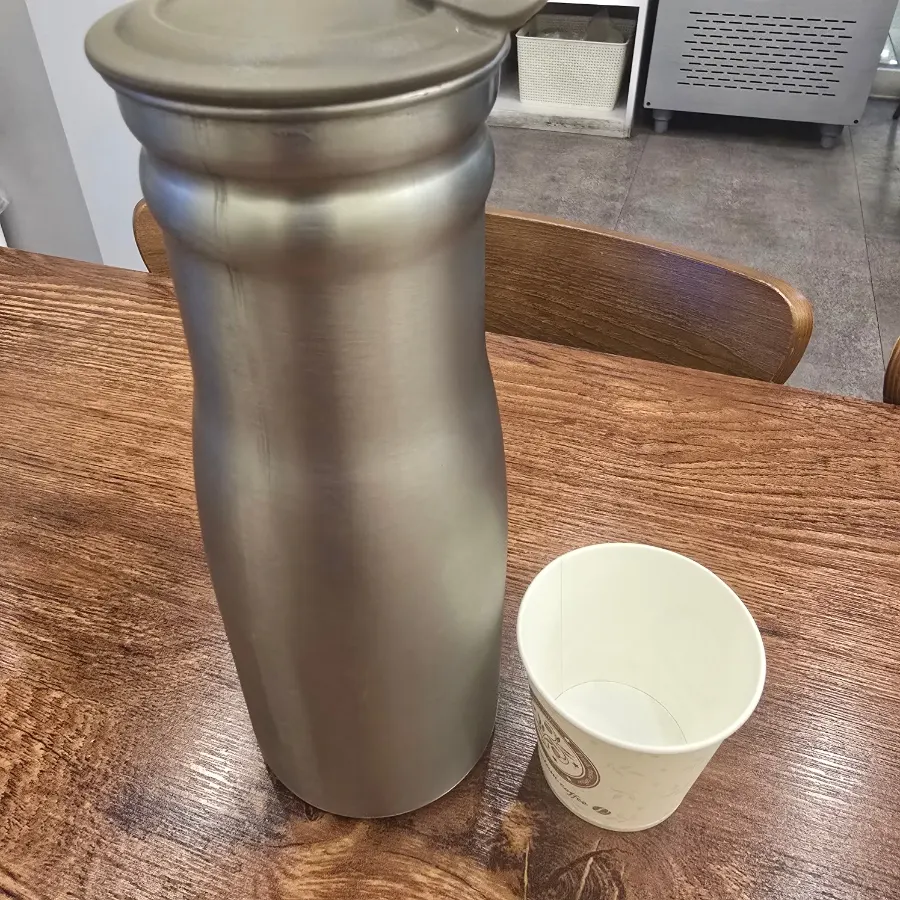 Water bottle and disposable paper cups on the table