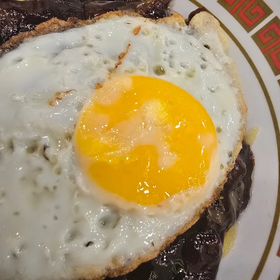 Close-up of the soft fried egg on top of the jjajangmyeon