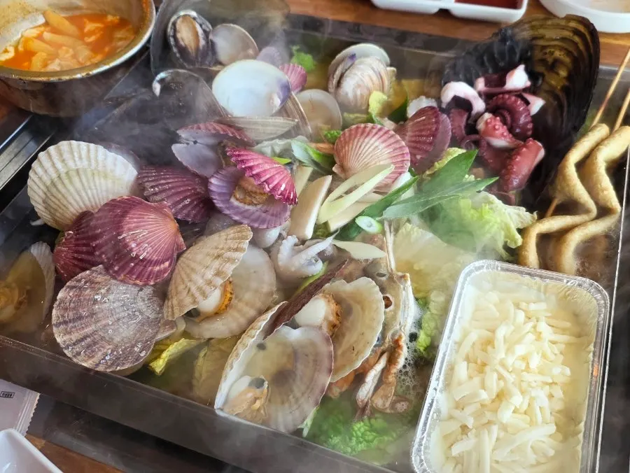 Table spread of the steamed clam soup as it starts to boil