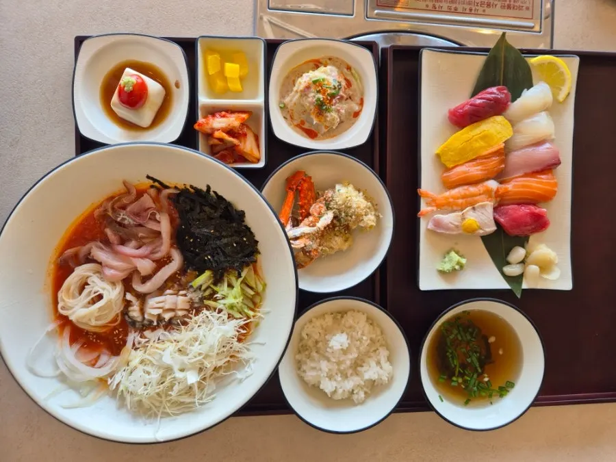 Table spread of the omakase aged sashimi sushi and live abalone mulhoe set